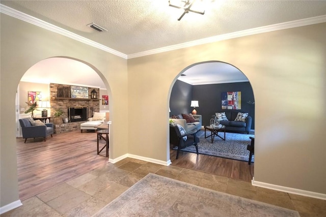 corridor with visible vents, a textured ceiling, baseboards, and ornamental molding