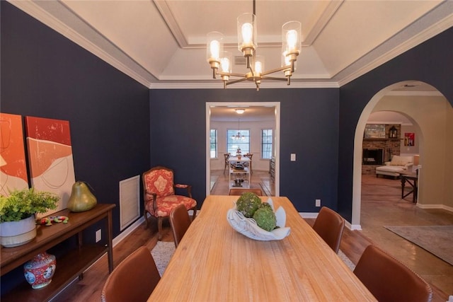 dining space featuring visible vents, a notable chandelier, arched walkways, crown molding, and baseboards