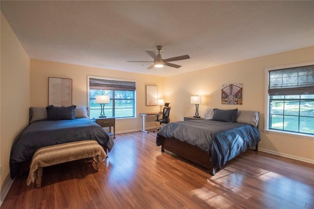 bedroom with ceiling fan, baseboards, and wood finished floors