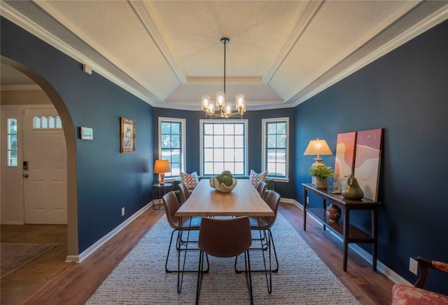 dining space featuring baseboards, arched walkways, and dark wood-style flooring