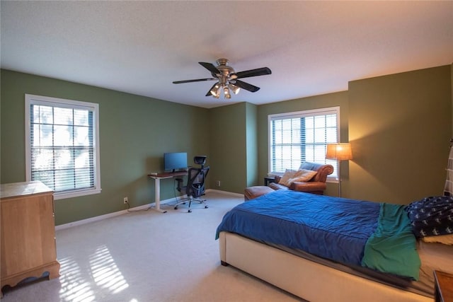 carpeted bedroom with baseboards, multiple windows, and a ceiling fan