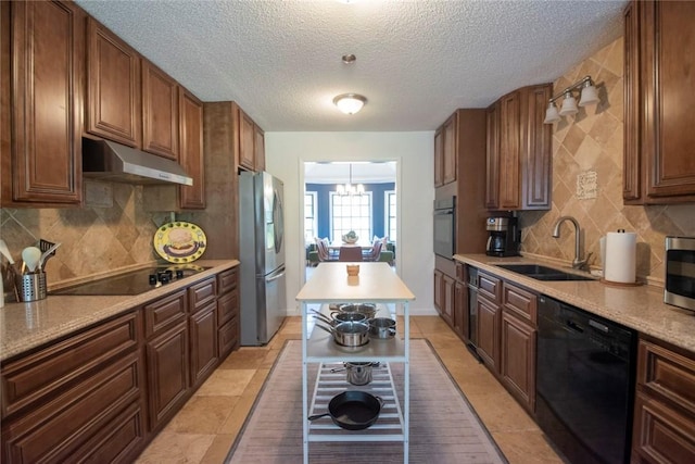 kitchen featuring a sink, black appliances, light countertops, under cabinet range hood, and backsplash