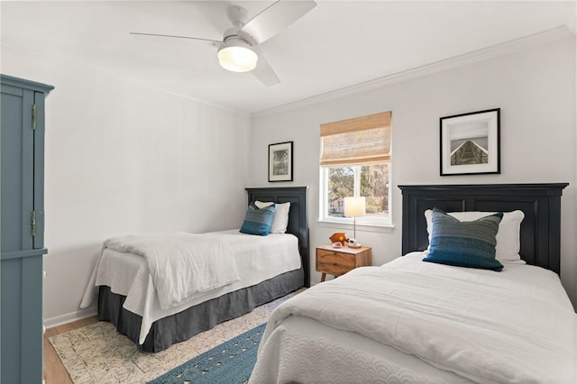 bedroom with ornamental molding, ceiling fan, wood finished floors, and baseboards