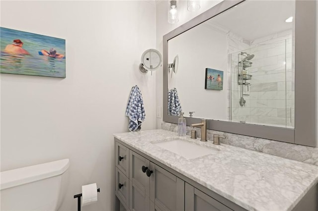 full bath featuring a tile shower, toilet, and vanity