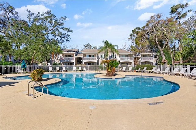 community pool featuring fence and a patio