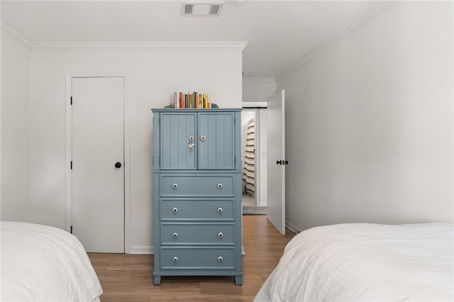 bedroom featuring crown molding and wood finished floors