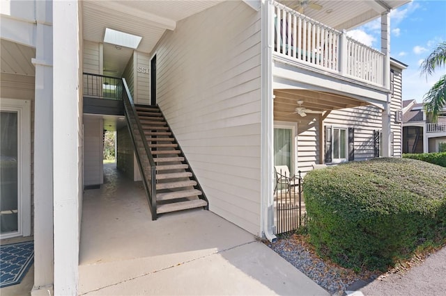 property entrance with a balcony and ceiling fan