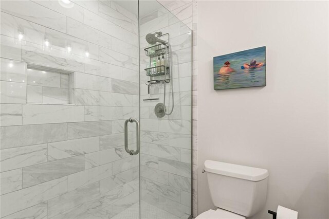bathroom featuring a shower stall and toilet