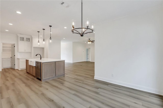 kitchen featuring light hardwood / wood-style flooring, an island with sink, decorative light fixtures, white cabinets, and ceiling fan with notable chandelier