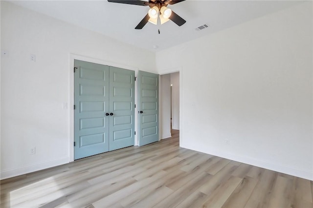 unfurnished bedroom with a closet, light hardwood / wood-style flooring, and ceiling fan