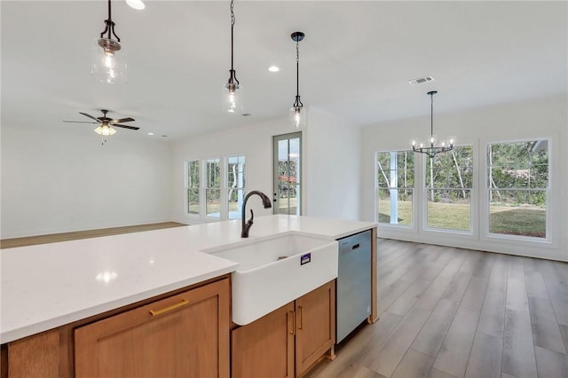 kitchen with ceiling fan with notable chandelier, light hardwood / wood-style flooring, stainless steel dishwasher, and hanging light fixtures