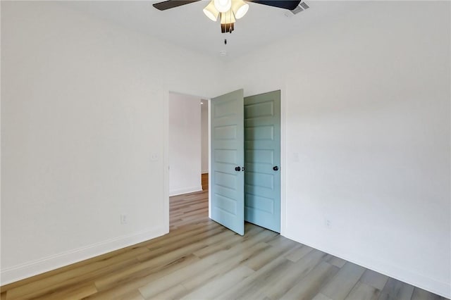 empty room featuring ceiling fan and light hardwood / wood-style flooring