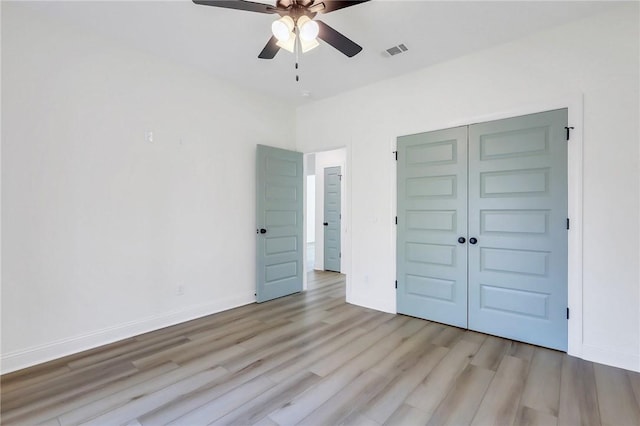 unfurnished bedroom with a closet, light hardwood / wood-style floors, and ceiling fan