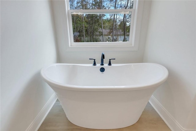 bathroom with a tub and hardwood / wood-style floors