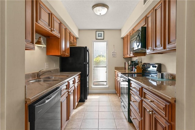 kitchen featuring a textured ceiling, sink, black appliances, dark stone countertops, and light tile patterned flooring