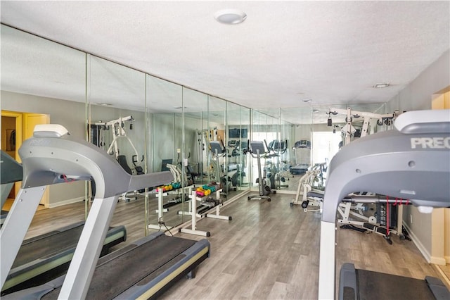 workout area with wood-type flooring and a textured ceiling