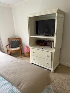 bedroom featuring crown molding and light carpet