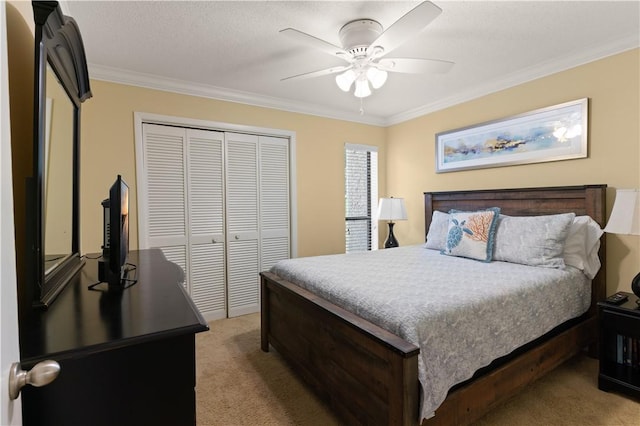 carpeted bedroom featuring ceiling fan, a closet, crown molding, and a textured ceiling