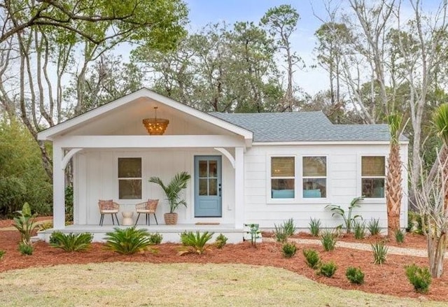 301 Kelsall Ave, Saint Simons Island, GA 31522 - view of front of house featuring covered porch, a shingled roof, and board and batten siding