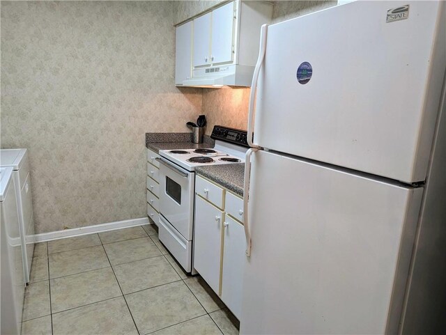 kitchen with light tile patterned floors, white appliances, and white cabinetry