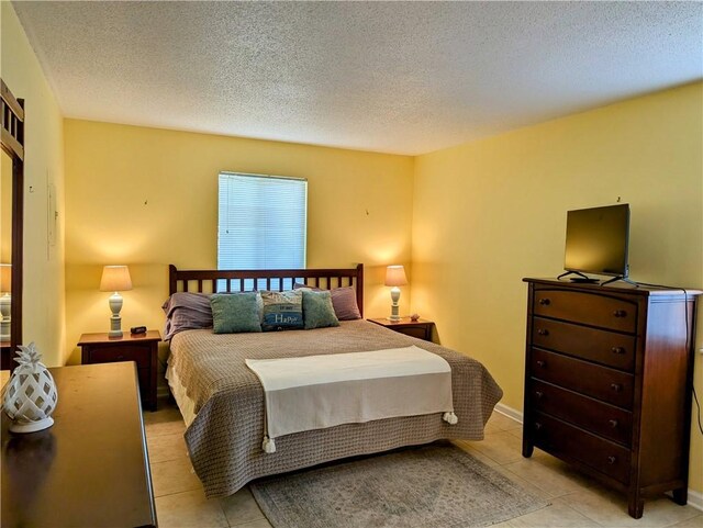 bedroom with light tile patterned flooring and a textured ceiling