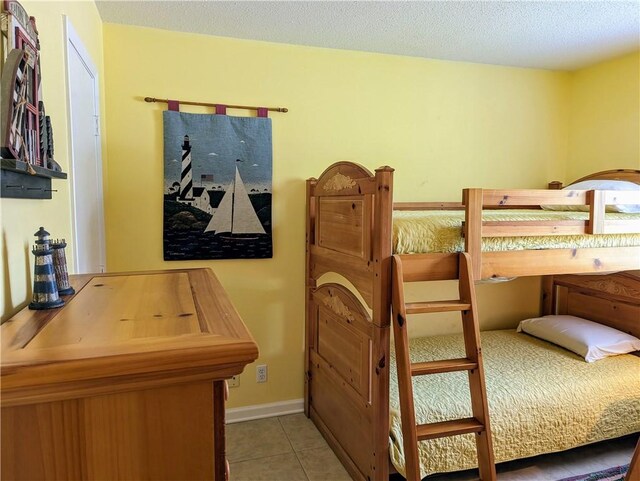 tiled bedroom with a textured ceiling