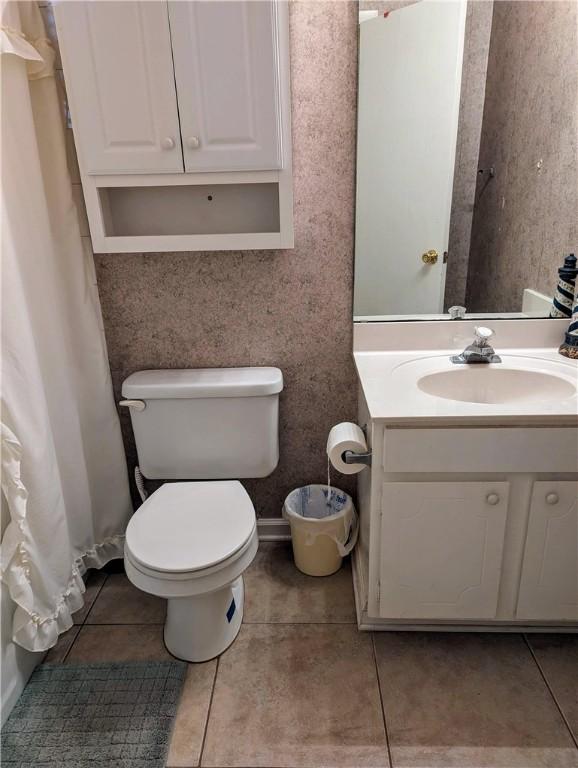 bathroom featuring tile patterned flooring, vanity, and toilet