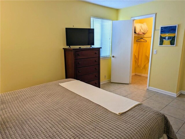 tiled bedroom with a spacious closet