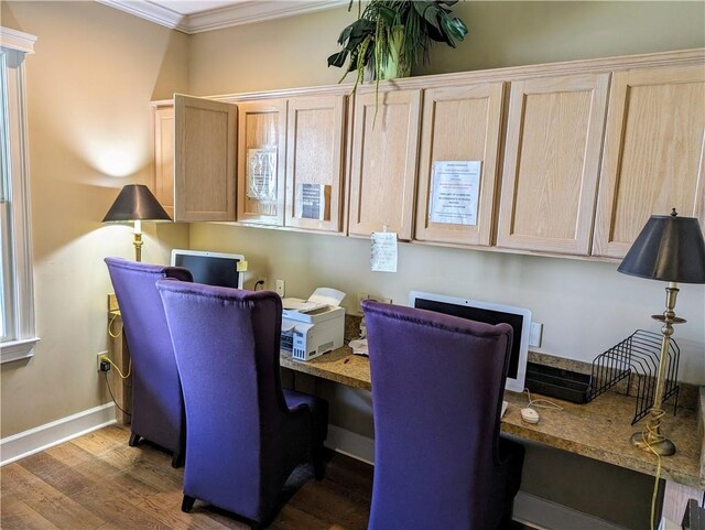 office with hardwood / wood-style floors, built in desk, and ornamental molding