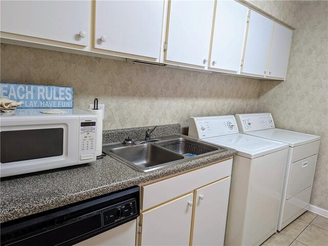 clothes washing area featuring light tile patterned flooring, washer and clothes dryer, and sink