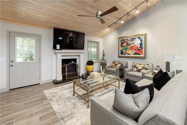 living room with ceiling fan, wood ceiling, track lighting, and a brick fireplace