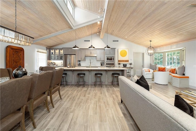 living room featuring sink, lofted ceiling with beams, light hardwood / wood-style floors, and wood ceiling