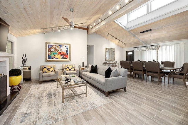 living room with wood ceiling, lofted ceiling, ceiling fan with notable chandelier, and rail lighting