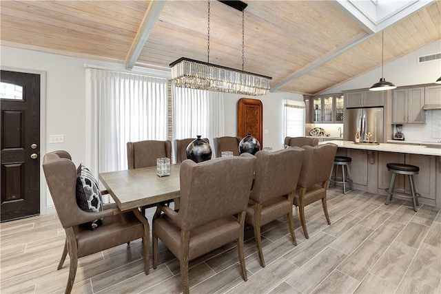 dining space with wooden ceiling, a chandelier, and lofted ceiling with beams