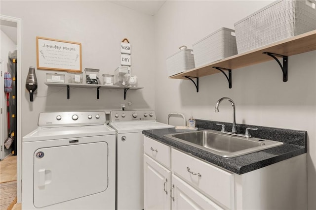 laundry room with cabinet space, a sink, and independent washer and dryer