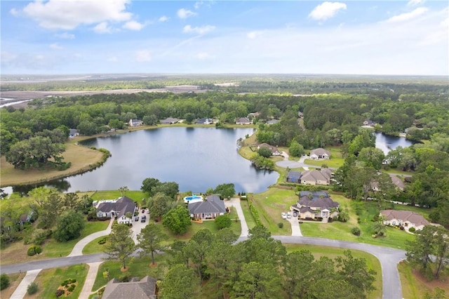 drone / aerial view featuring a residential view, a water view, and a wooded view