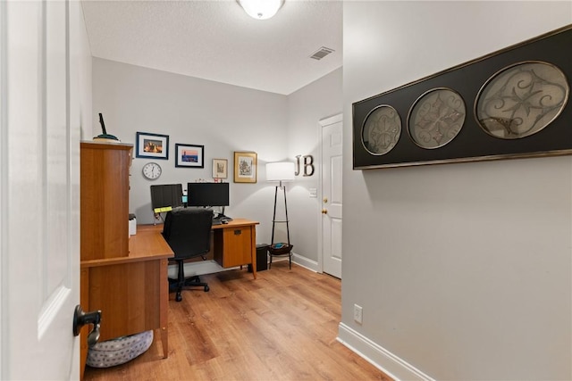 office space with visible vents, wood finished floors, and baseboards