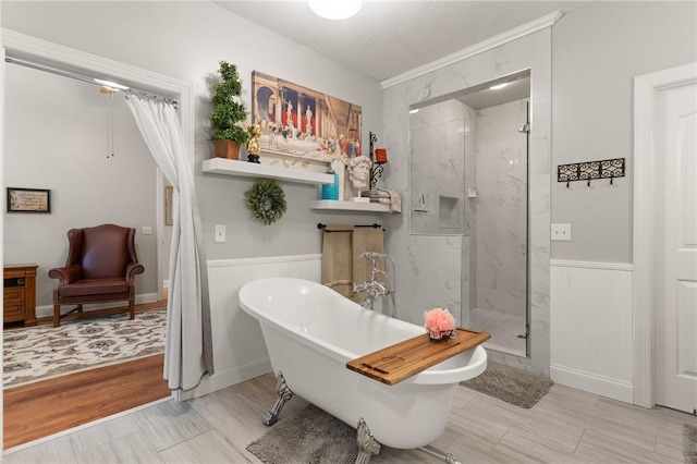 full bathroom with a marble finish shower, wainscoting, and a soaking tub