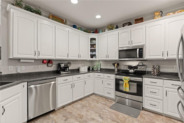 kitchen featuring recessed lighting, dark countertops, white cabinetry, and stainless steel appliances