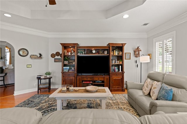 living area featuring visible vents, arched walkways, recessed lighting, ornamental molding, and wood finished floors