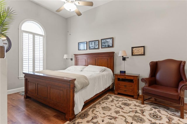 bedroom with lofted ceiling, wood finished floors, ceiling fan, and baseboards