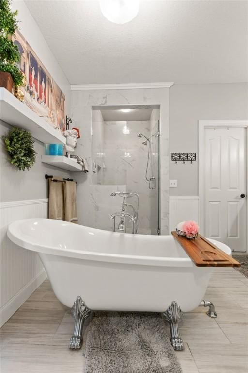 bathroom featuring a freestanding tub, a stall shower, and wainscoting