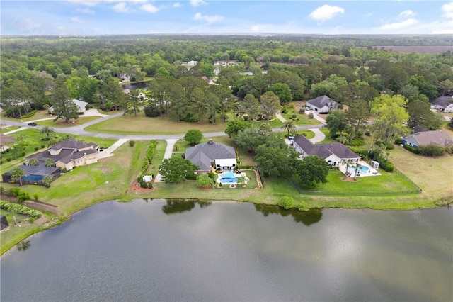 drone / aerial view with a water view, a residential view, and a forest view