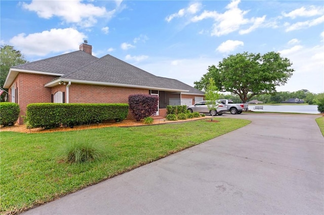 view of property exterior featuring concrete driveway, a chimney, a shingled roof, a lawn, and brick siding