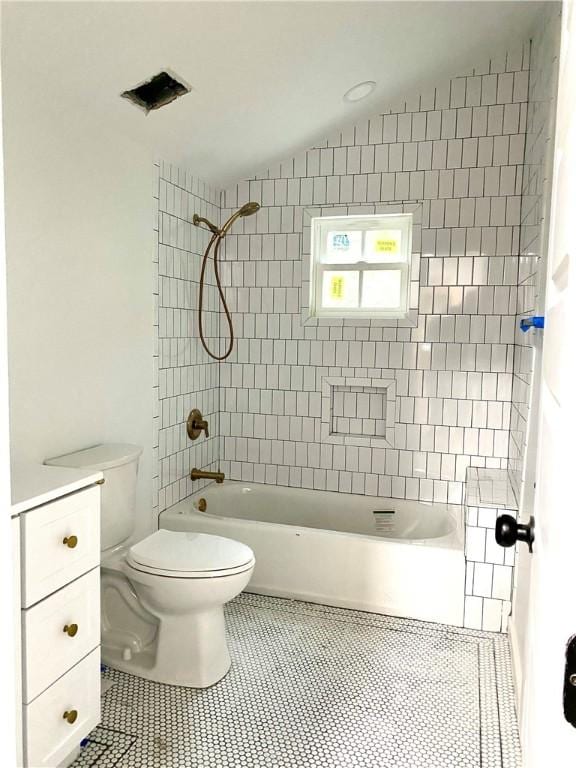 bathroom featuring tile patterned floors, toilet, and tiled shower / bath