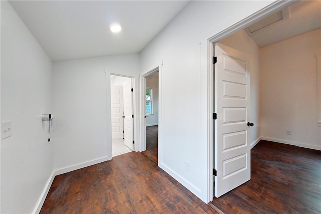 hallway featuring dark wood-type flooring and lofted ceiling