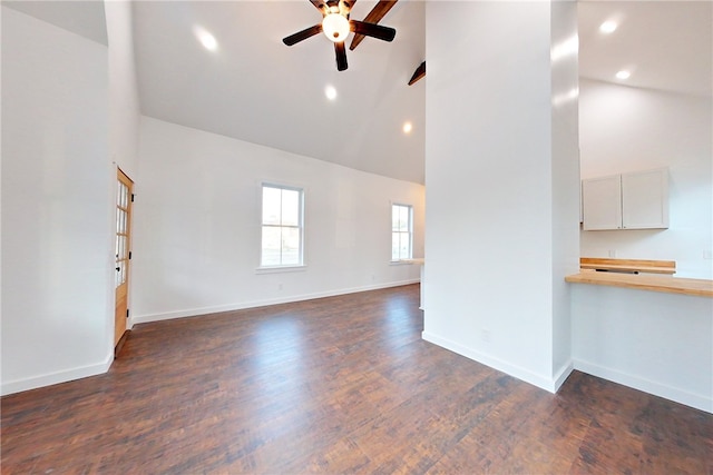 unfurnished living room featuring high vaulted ceiling, dark hardwood / wood-style floors, and ceiling fan