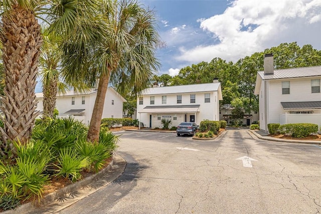 132 S Island Square Dr, Saint Simons Island, GA 31522 - view of front facade with uncovered parking and a chimney