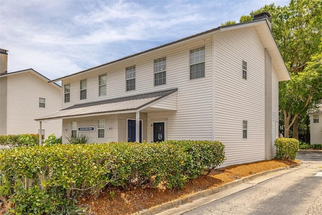 132 S Island Square Dr, Saint Simons Island, GA 31522 - view of property with a chimney and a metal roof