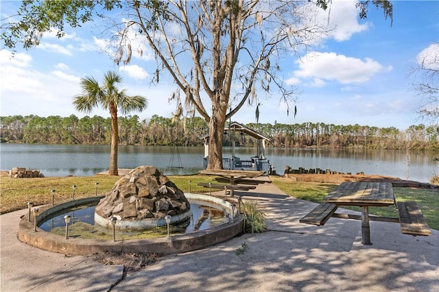 view of community featuring an outdoor fire pit and a water view